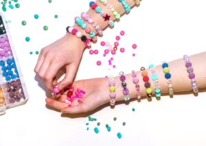 girl making colorful bead bracelets