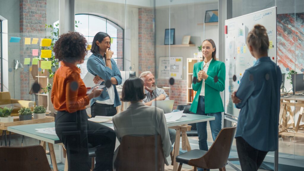 Team meeting in a creative office discussing strategy and growth plans, symbolizing the support structure behind an Onlyfans Management Company